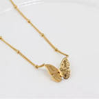 Gold butterfly necklace on a white background